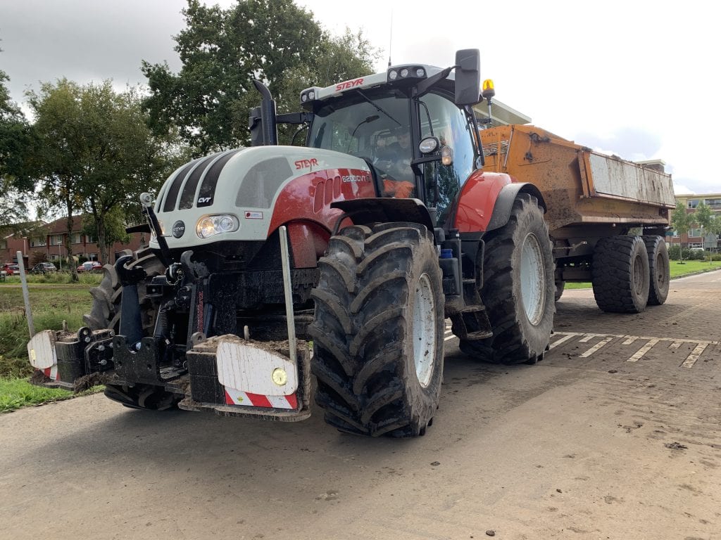 Tractor met dumper en haakarm