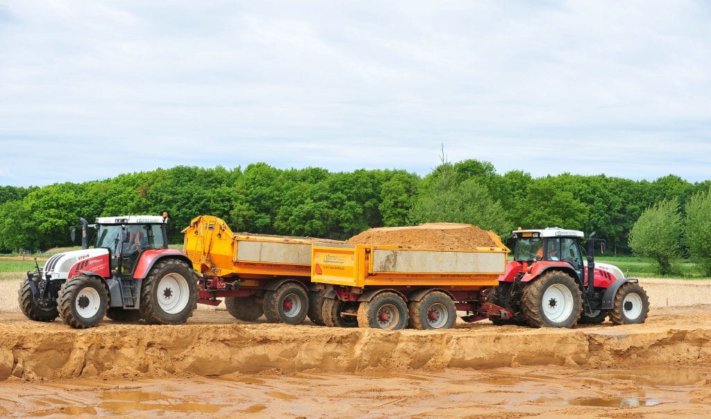 Tractor met dumper en haakarm